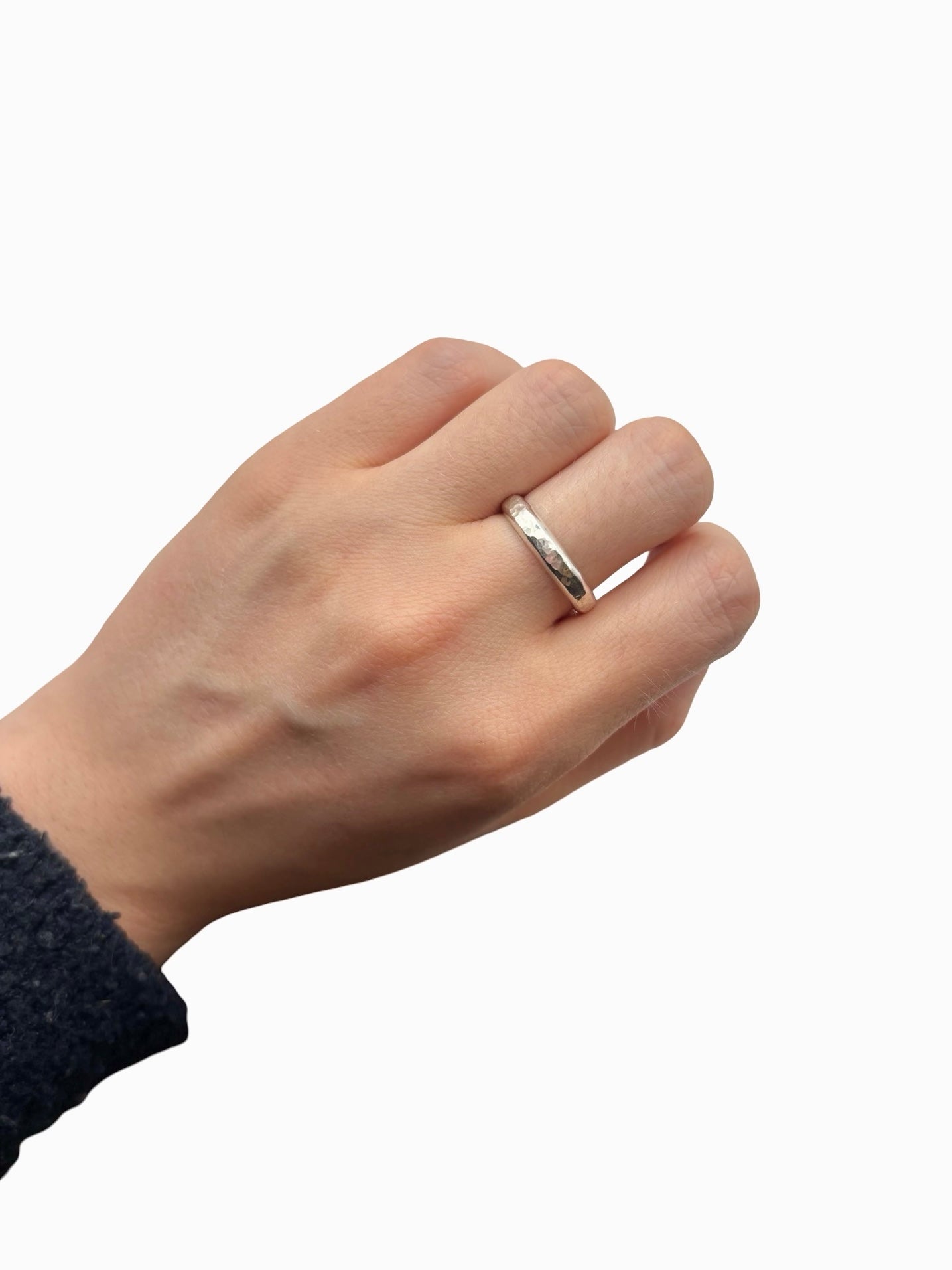 Hand wearing a silver ring on a white background