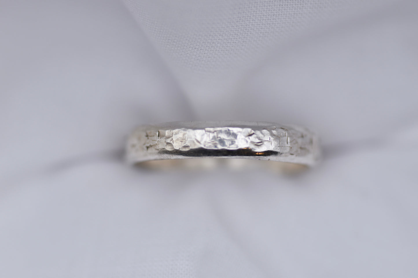 Silver ring with texture light gray background