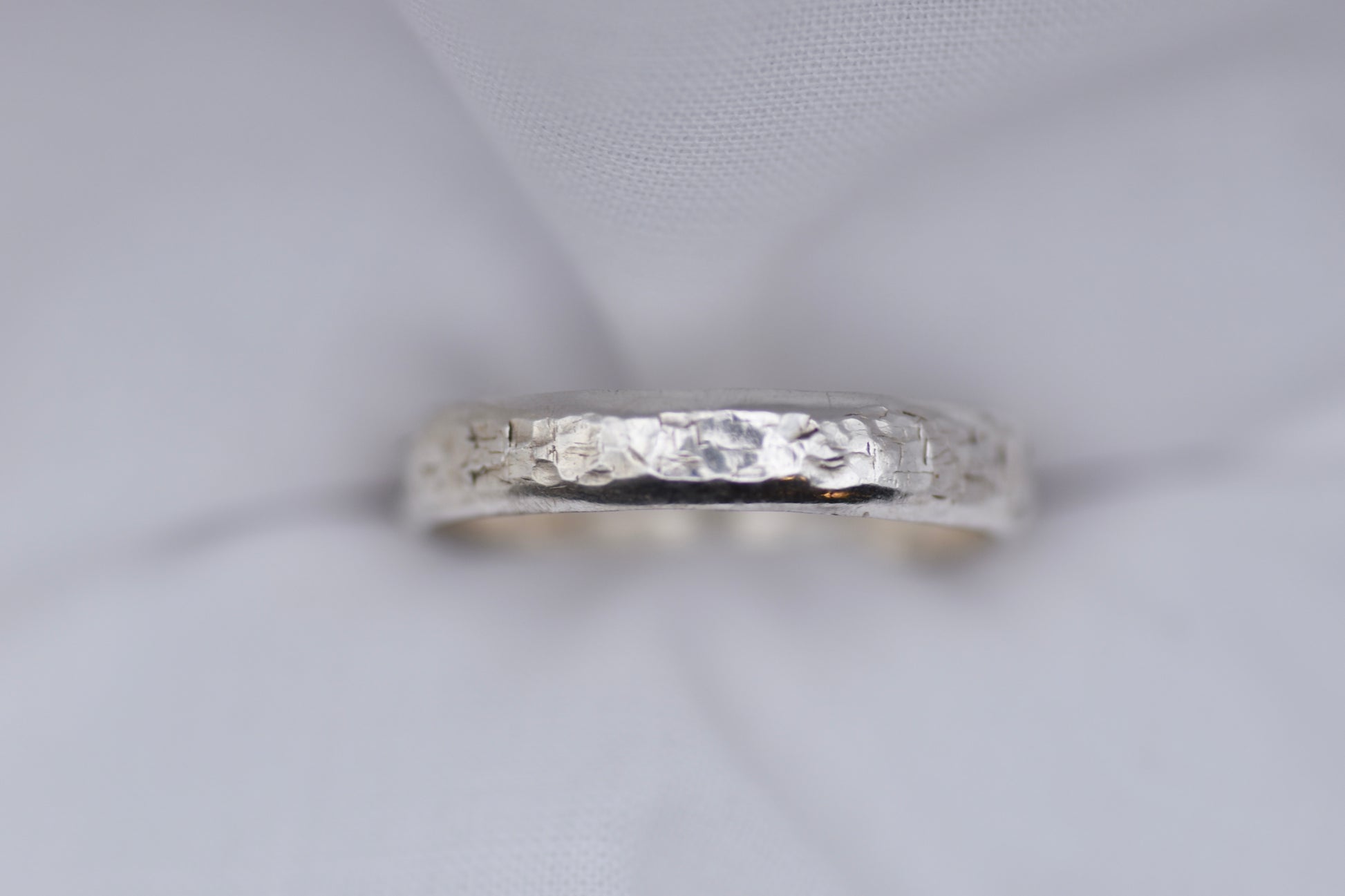 Silver ring with texture light gray background